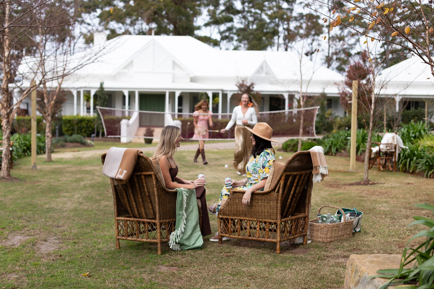 Guests relaxing on wicker lounge seating in front of Verandah House Country Estate