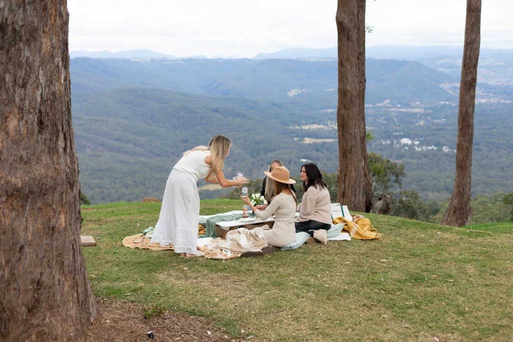 Ladies in rattan armchairs at a garden party outside Verandah House